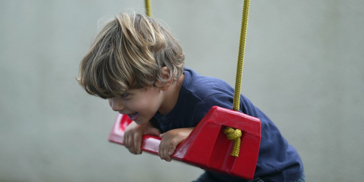 Junge hängt an Schaukel