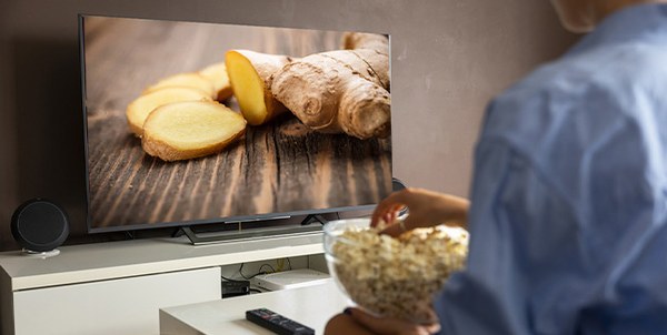 Eine Person guckt sich Ingwer im Fernsehen an mit Popcorn.