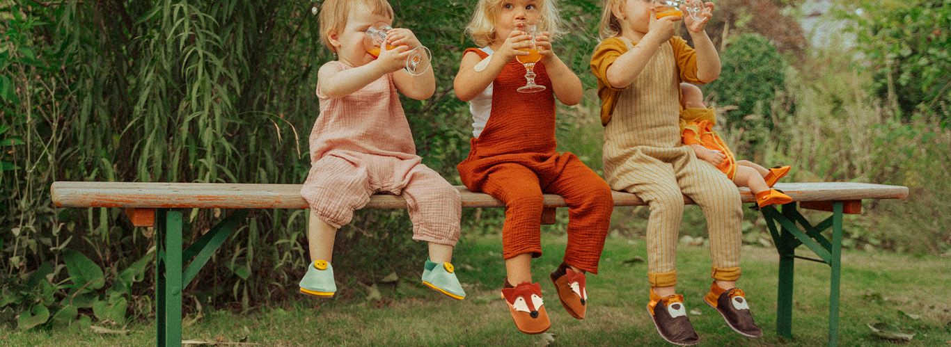 Zwei Kinder spielen drinnen und haben Hausschuhe an