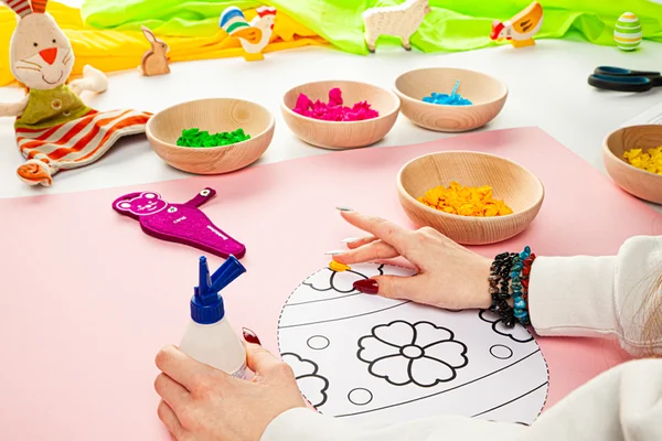 Die Knüddelchen befinden sortiert in Schalen und werden auf die Vorlage zum Ausdrucken geklebt.