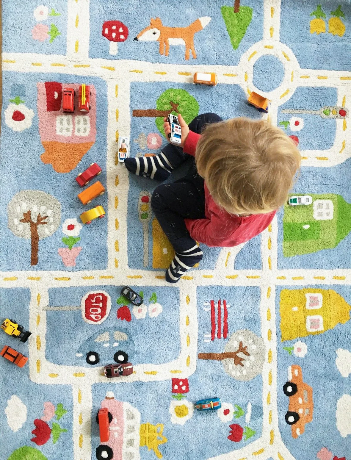 Kind sitzt auf unserem Strassen-Teppich