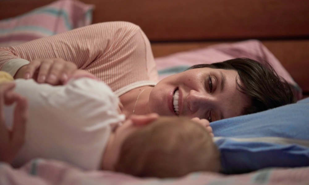 Mutter und Baby liegen im Familienbett
