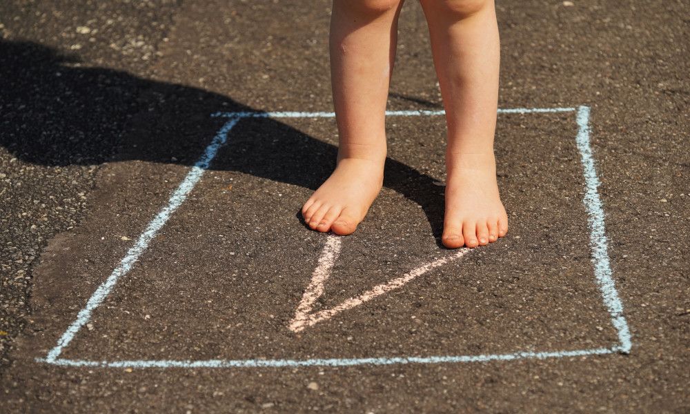 Kind spielt Hüpfspiel