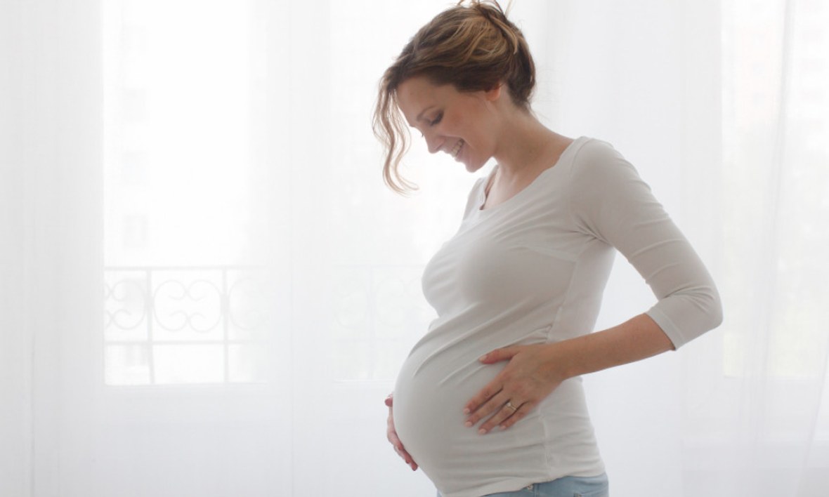 Schwangere hält ihren Bauch und ist voller Vorfreude