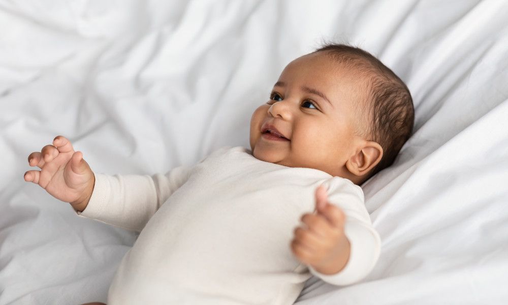 Glückliches, lachendes Baby im Babybody