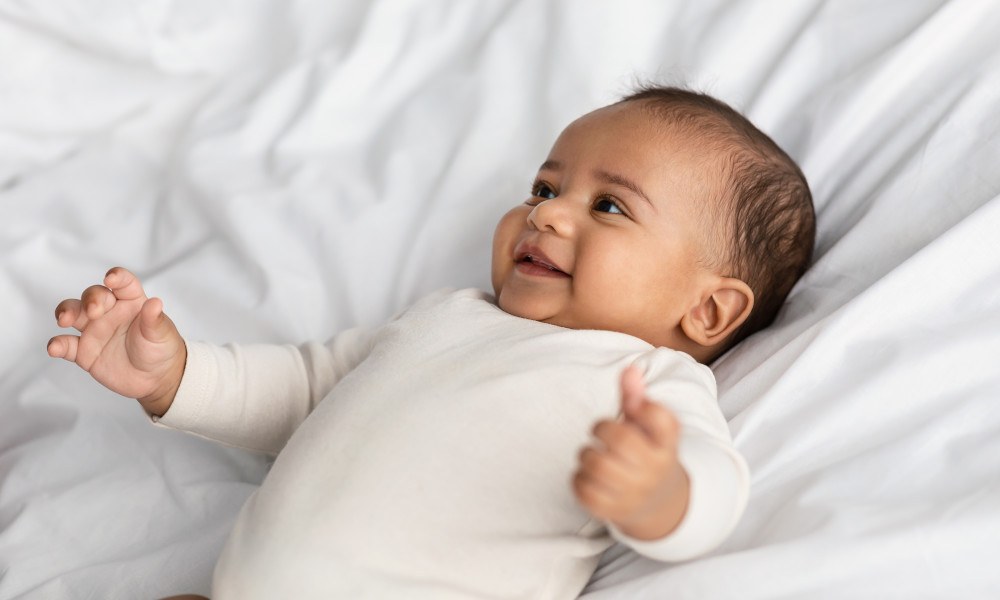 Glückliches, lachendes Baby im Babybody