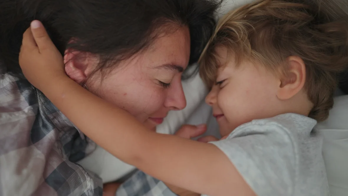 Mutter und Sohn sehen sich verschlafen in die Augen.