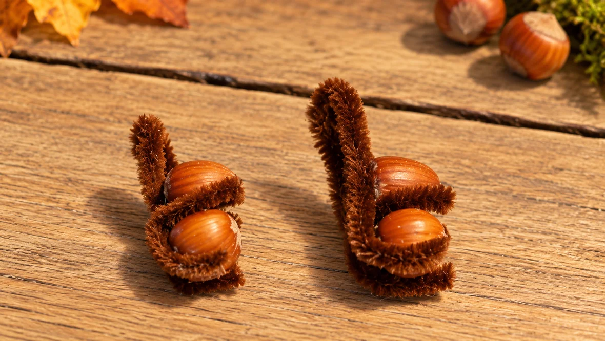 Handgemachte Haselnuss-Figuren auf Holz