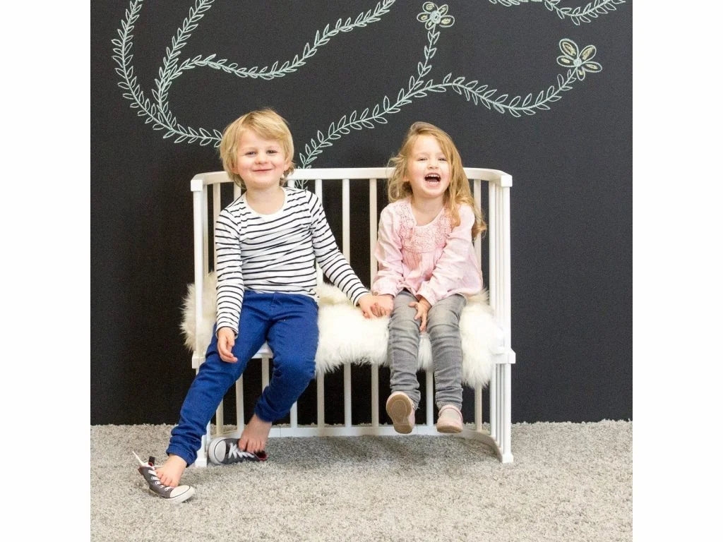 Zwei Kinder sitzen auf umgebautem Babybay