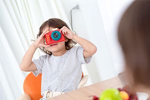 Junge blickt durch Spiezeugkamera