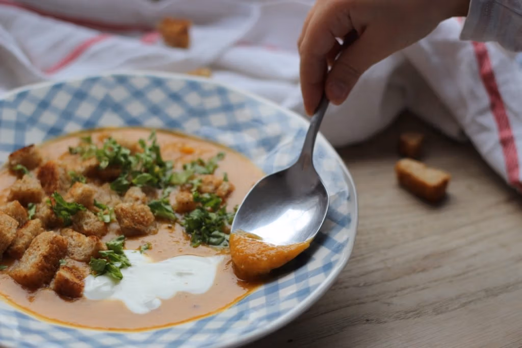 Kinderhand löffelt cremige Suppe