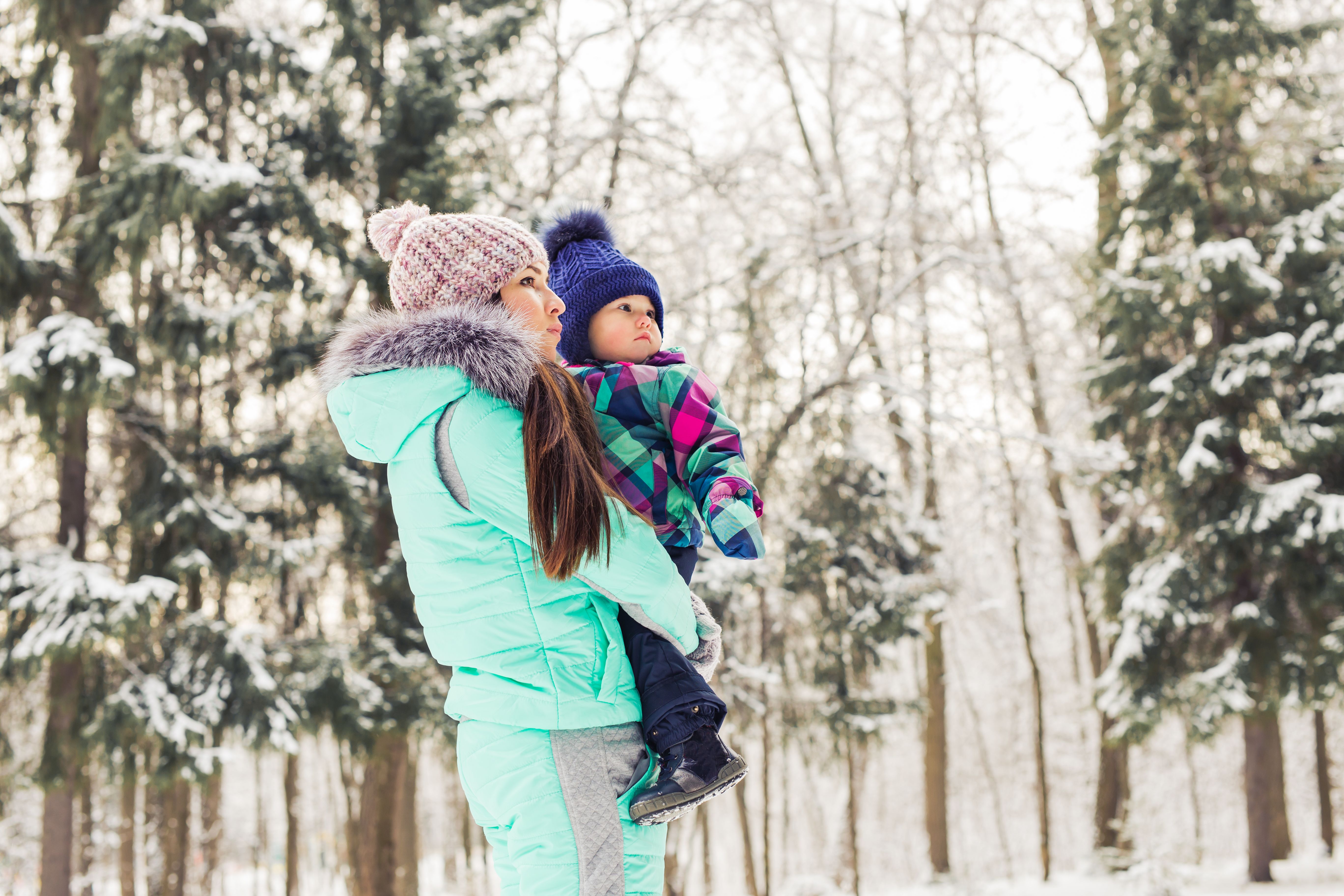 Baby mit Mutter im Wald Winterzeit