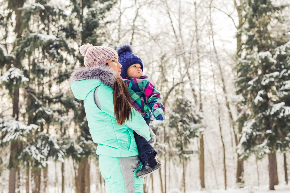 Baby mit Mutter im Wald Winterzeit