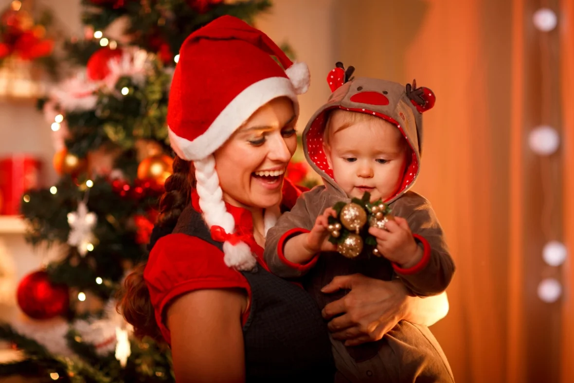 Mutter mit Baby in Weihnachtskostümen