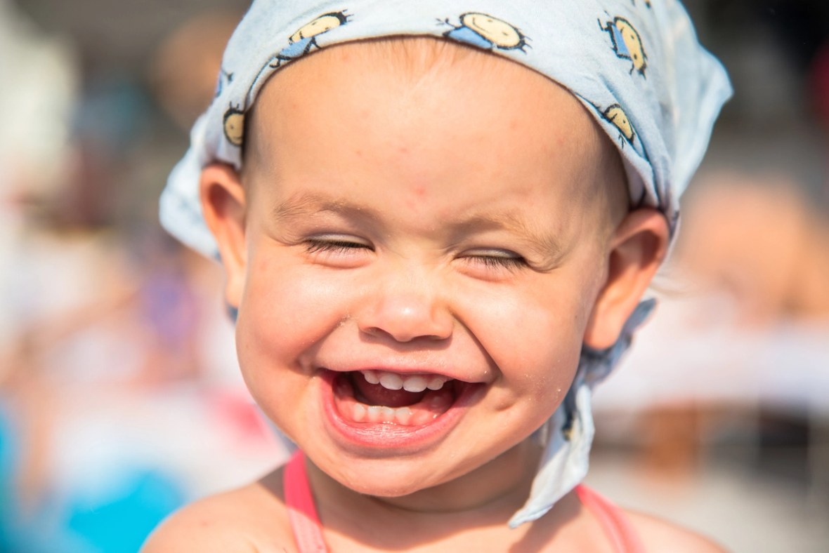 Glückliches Kind mit Sonnenschutz auf dem Kopf.