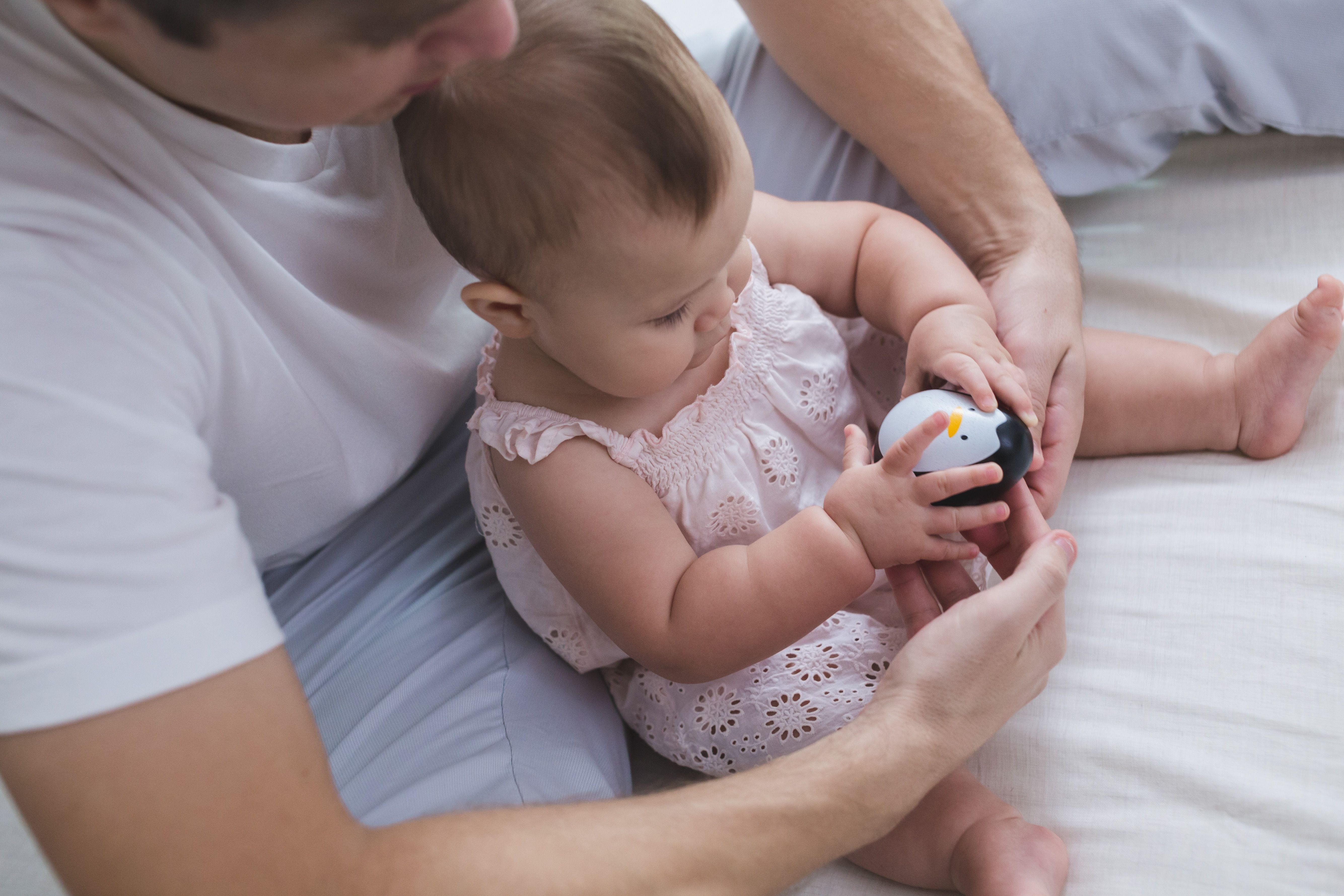 Vater und Kind spielen mit Pinguin Figur