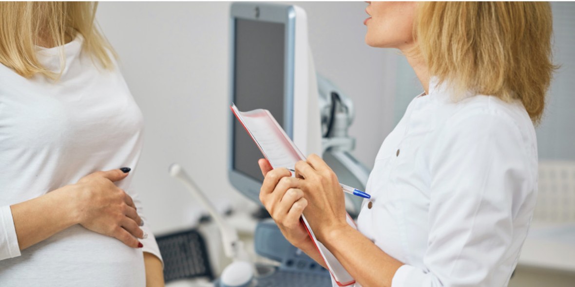 Ärztin unterhält sich mit Schwangerer über Kaiserschnitt