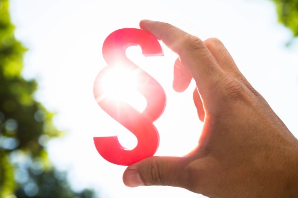 Nahaufnahme der Hand einer Person mit rotem Absatzsymbol