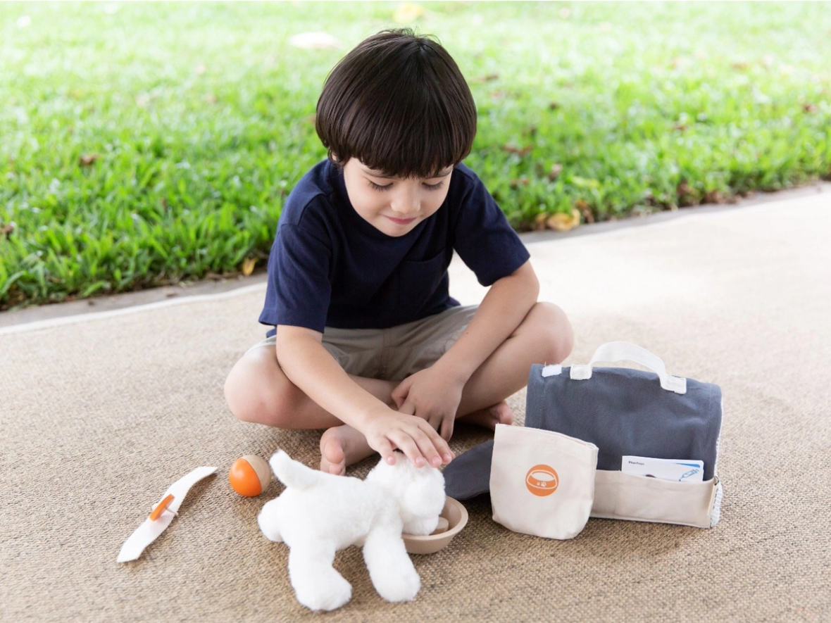 Junge spielt Tierarzt mit Spielzeughund