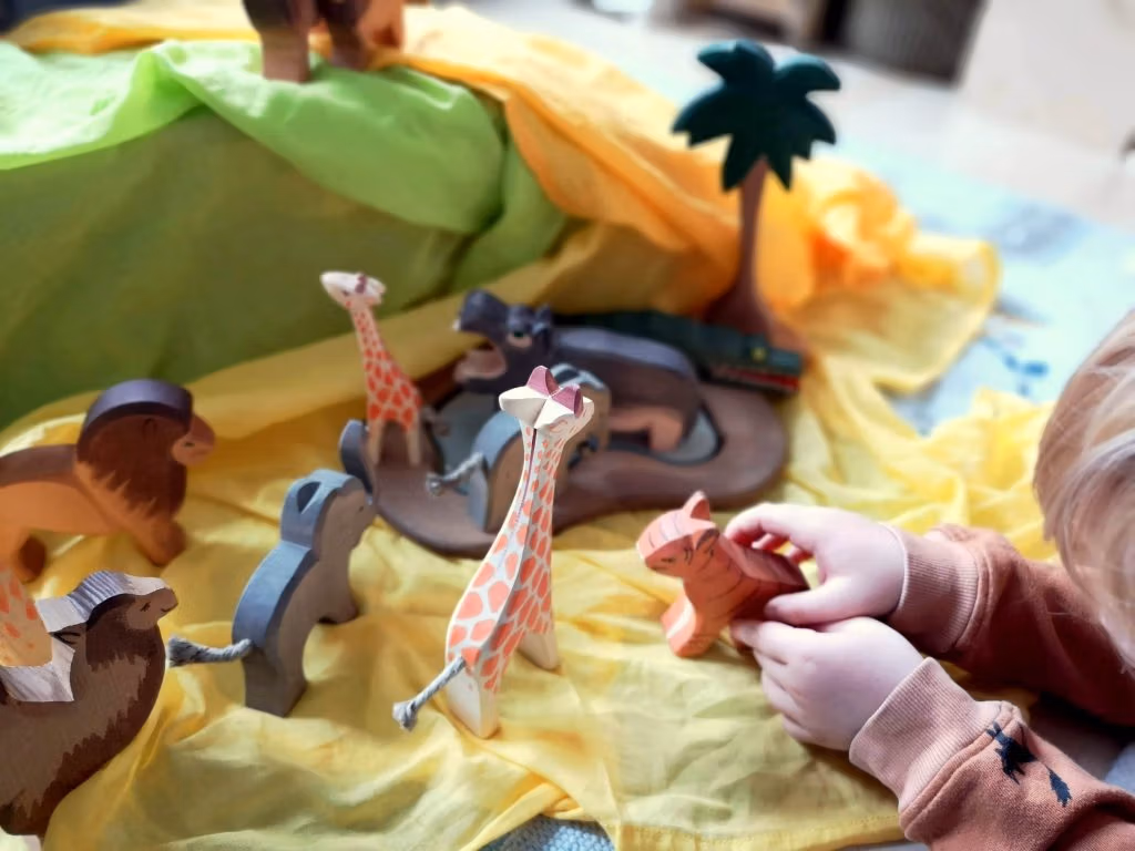 Bunte Spieltüchern in Kombination mit Holzfiguren und Holzbausteinen