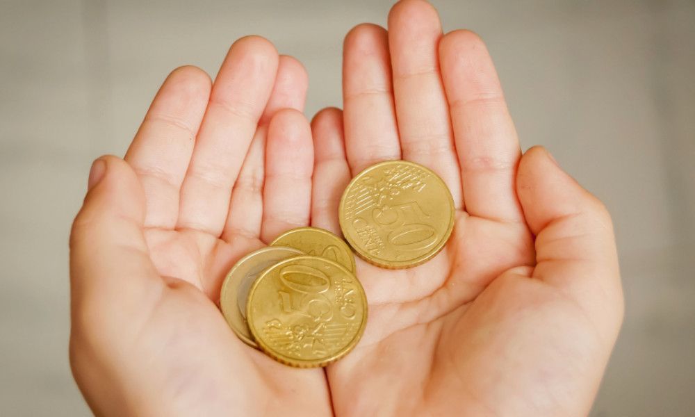 Kinderhände halten Euros in Münzgeld