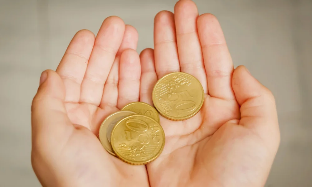 Kinderhände halten Euros in Münzgeld