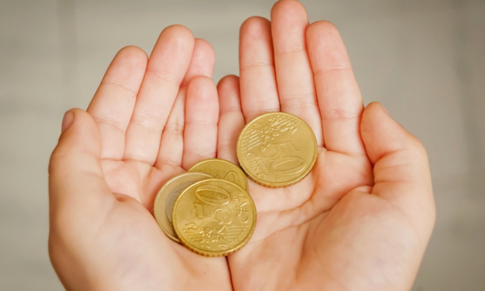 Kinderhände halten Euros in Münzgeld