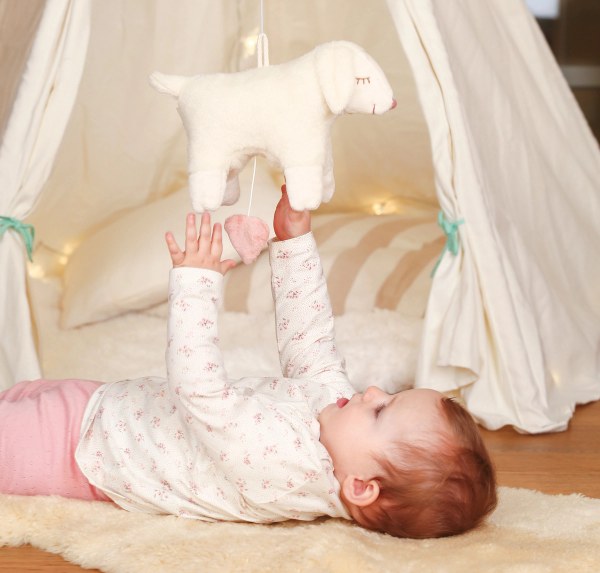 Baby spielt mit Kuscheltier Schaf von SENGER