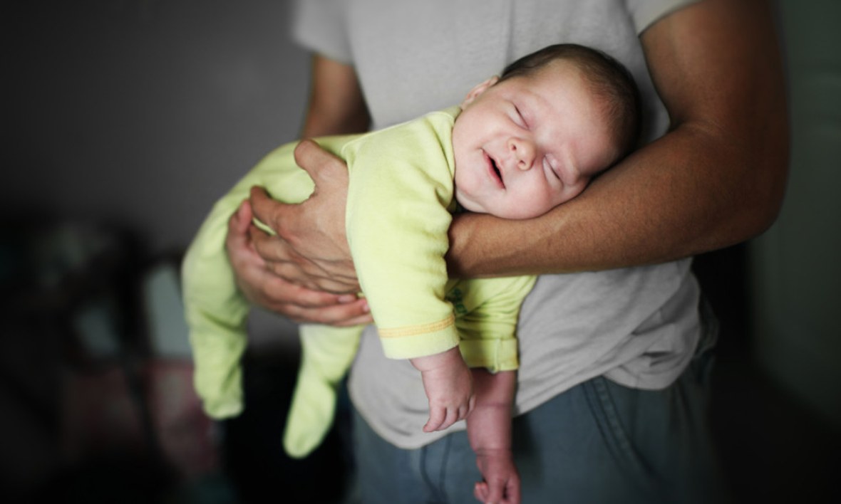 Glückliches Baby schläft auf dem Arm.