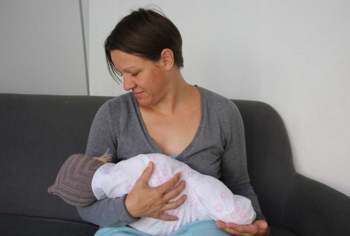 Gepucktes Baby liegt bei Frau im Arm